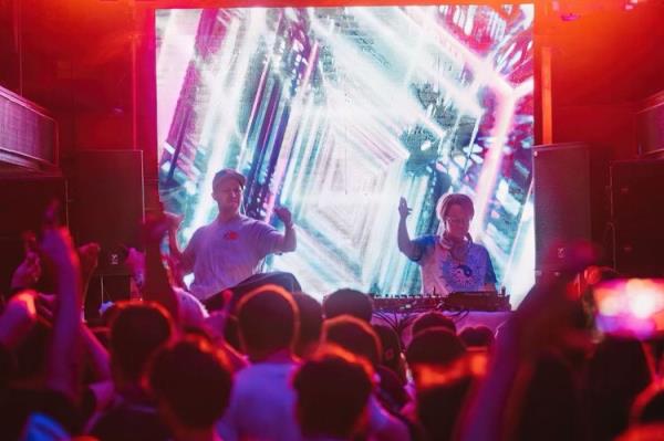 A group of people on a stage with a large screen at Hearsay Club, New York