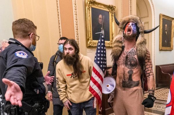 Jacob Chansley, right, will have his spear and horned helmet returned to him after a federal ruling on Monday.