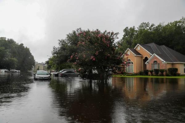 A car sits in high flood waters on Gentry Street on August 6, 2024 after heavy rains from Tropical Storm Debby caused major flooding at Barrington Estates in Pooler.