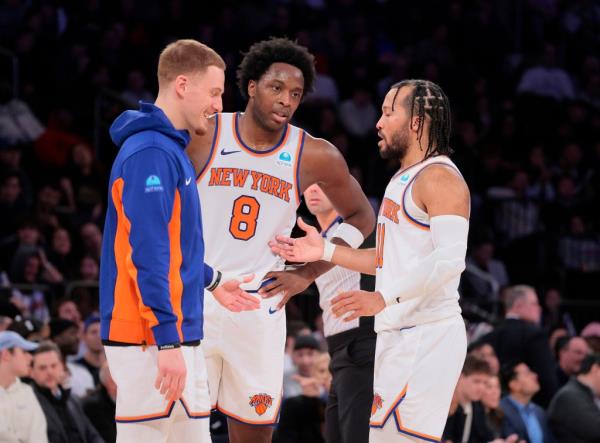 Knicks guard Jalen Brunson #11 speaks with forward OG Anunoby #8 and guard Do<em></em>nte DiVincenzo #0 on the court.