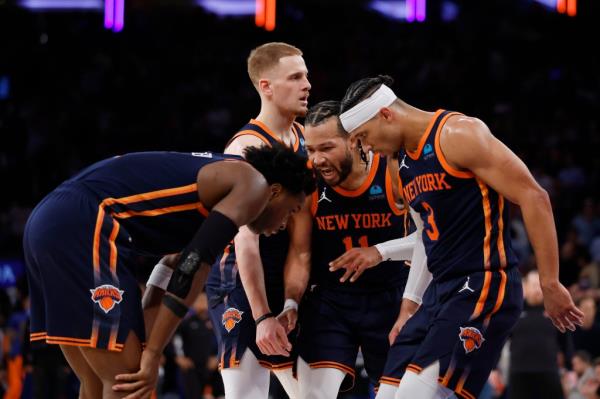 Jalen Brunson of the Knicks huddles with Josh Hart, Do<em></em>nte DiVincenzo, and OG Anunoby during Game agains the 76ers.