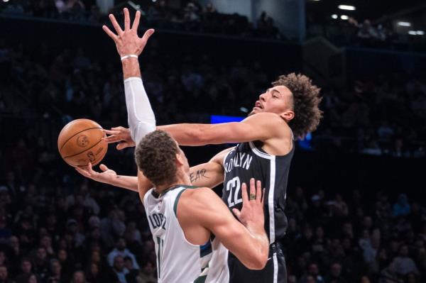 Nets forward Jalen Wilson (22) shoots around Milwaukee Bucks center Brook Lopez