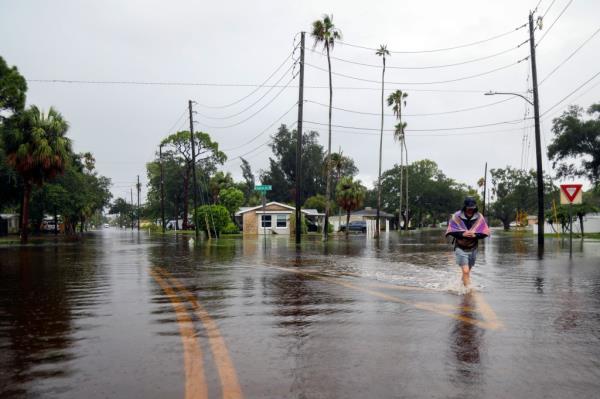 Carter Grooms, 25, of Tampa walking through flood waters in St. Petersburg after Debby hit the area on Aug. 5, 2024.