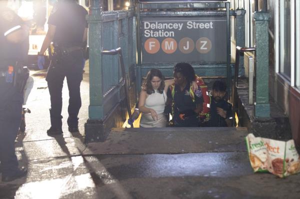 Police and EMS assist one of two women who were pushed  o<em></em>nto the subway tracks.