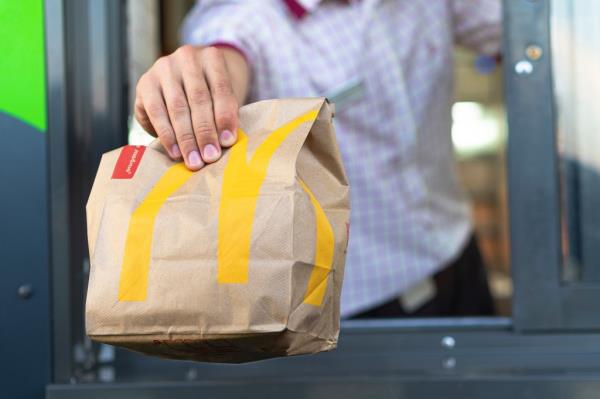 McDonald's worker in Sankt-Petersburg, Russia handing over a bag of fast food through the drive-thru window on July 21, 2019.