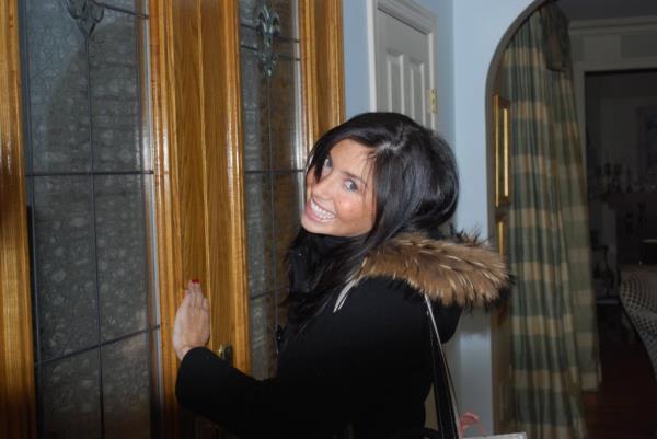 Ellen Greenberg smiling with her hand on a door