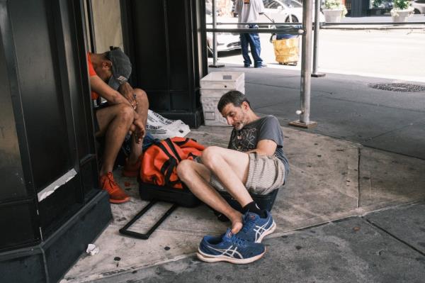 Two drug users nod out on 30th street and Broadway in midtown Manhattan. 