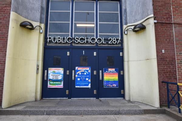 Entrance to PS 287 school in Brooklyn, New York with colorful signs on the doors a<em></em>bout summer programs and describing drop-off/pick-up entrances.