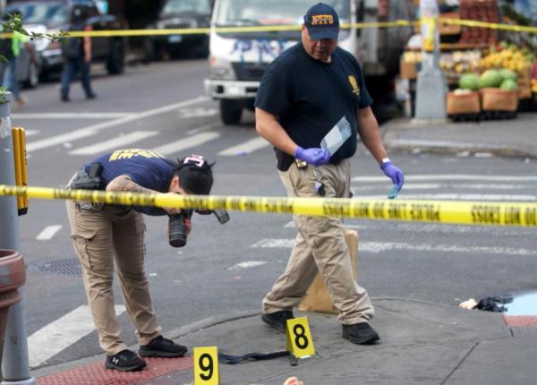 NYPD officers investigating the scene of the shooting in Queens.