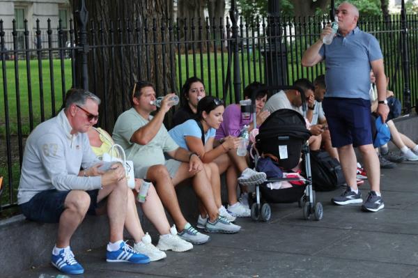 Ingrid Wu and a<em></em>bout 10 others sit in the shade drinking water near City Hall on a hot and humid day, August 01, 2024, in New York City with a heat advisory in effect