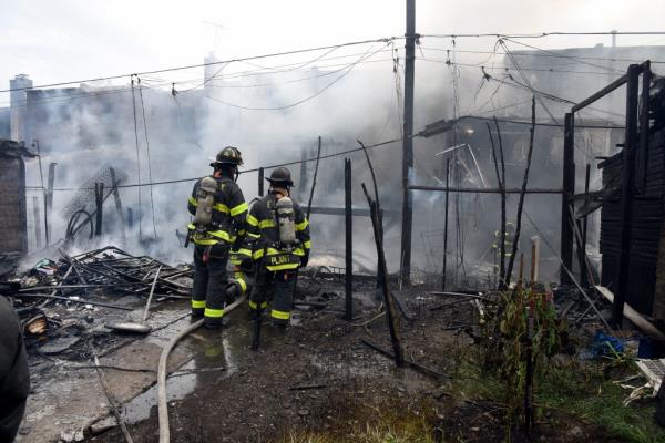 Firefighters examining damage at one of the houses.