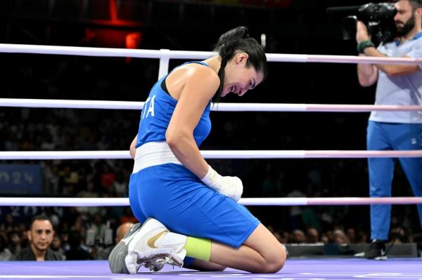 Italian boxer Angela Carini in blue uniform, reacting after her women's 66kg round of 16 boxing match at Paris 2024 Olympic Games.