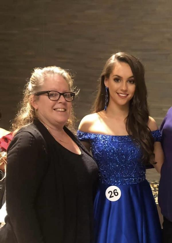 Lee Hudson and her daughter Jordon Judson lean in and smile for a picture. Jordon is in a dark blue gown and her mom is wearing black.