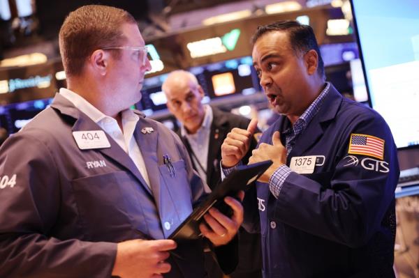 Traders discussing on the New York Stock Exchange floor, anticipating an interest rate decision, July 31, 2024