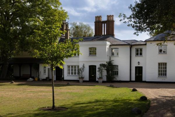 Frogmore Cottage in Windsor, UK, a white house with a lawn and trees, sitting empty after being vacated by The Duke and Duchess of Sussex.