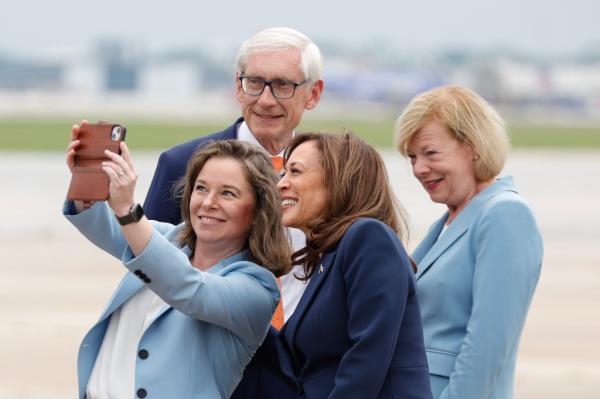 US Vice President and Democratic presidential candidate Kamala Harris (2R) gathers for a picture with Wisco<em></em>nsin Lieutenant Governor Sara Rodriguez (L), Wisco<em></em>nsin Governor Tony Evers (2L) and US Senator Tammy Baldwin, Democrat of Wisconsin, upon arrival at Milwaukee Mitchell Internatio<em></em>nal Airport on July 23, 2024, in Milwaukee, Wisconsin. 