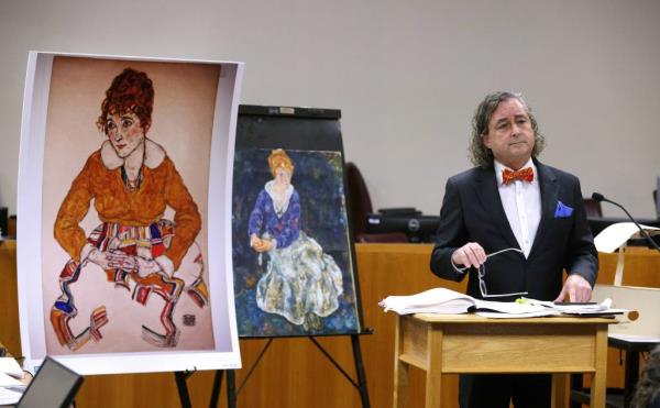 Attorney Raymond Dowd standing with reproductions of artworks during a trial in Supreme Court, Rochester