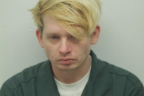 Joshua McGregor is pictured in a mugshot with short, messy blo<em></em>nde hair and a sad face