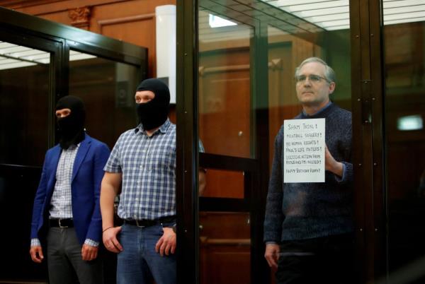 Former U.S. Marine Paul Whelan, accused of espionage, holding a sign inside a defendants' cage during his verdict hearing in Moscow, Russia, on June 15, 2020.