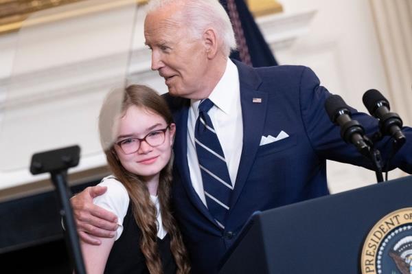 US President Joe Biden embraces Miriam Butorin, the 12-year-old daughter of Aslu Kurmasheva, as he speaks a<em></em>bout the priso<em></em>ner exchange with Russia, in the State Dining Room of the White House in Washington, DC, on August 1, 2024.