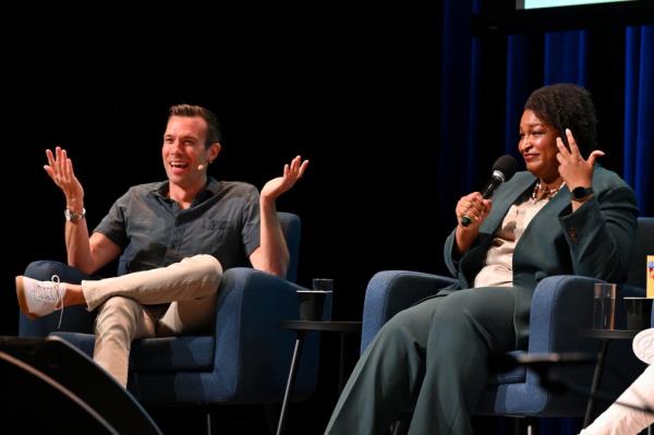 Staffers at Crooked Media have reportedly grown resentful of Favreau's wealth and celebrity status. Favreau is seen left with former Georgia gubernatorial candidate Stacey Abrams.