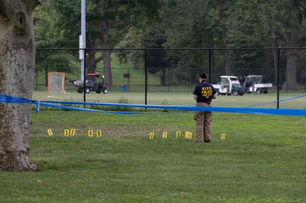 Yellow cards mark shell casings at the scene of a triple shooting on Randall's Island in New York, Monday, July 29, 2024 as police investigate. 