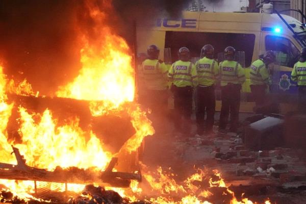 Riot police stand near a fire during a protest in Southport following the fatal stabbings.