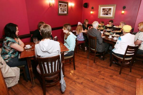 A group of people sitting at tables in Alice's Tea Cup restaurant located at 102 West 73rd Street in Manhattan