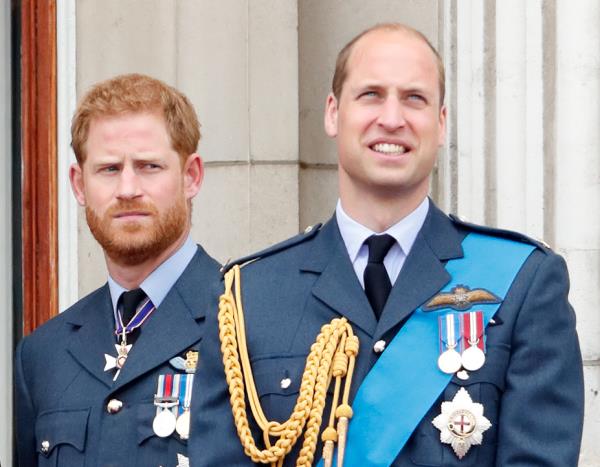 Prince William and Prince Harry in military uniforms watching a flypast from the balcony of Buckingham Palace to mark the centenary of the Royal Air Force