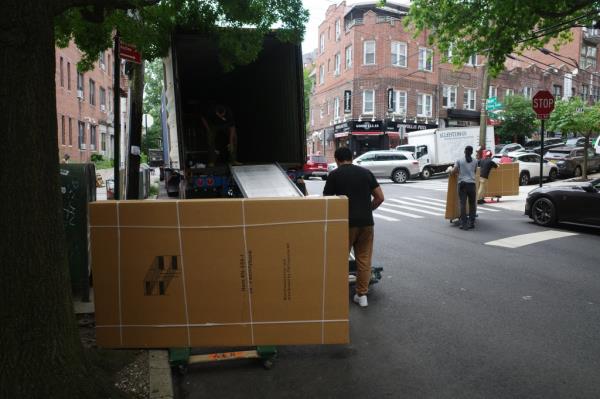 Workers move items into a migrant center that will be opening soon at 435 West 238th Street. 