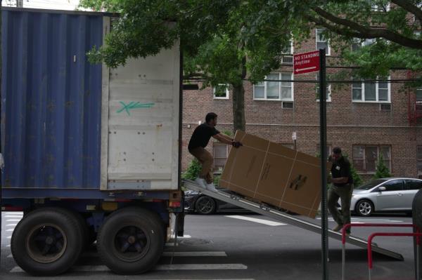 Workers move items into a migrant center that will be opening soon at 435 West 238th Street. 