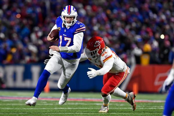 Buffalo Bills quarterback Josh Allen carrying the ball against Kansas City Chiefs' defensive end Mike Danna, in a NFL AFC division playoff football game.