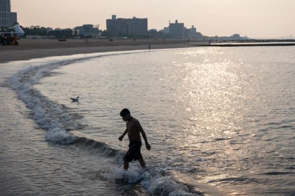 A man swimming in the early morning at the beach at Co<em></em>ney Island