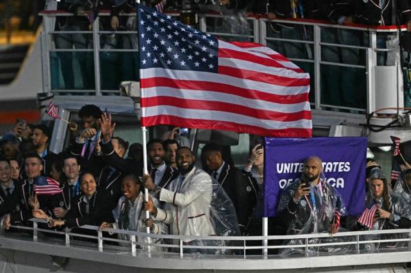 Flag bearer LeBron James holds the American flag on Team USA's boat.