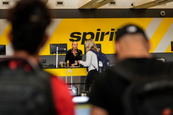 A traveler speaks with a Spirit Airlines official.