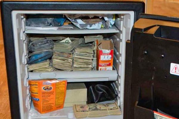 Up-close image of cash stuffed inside a mini-fridge.