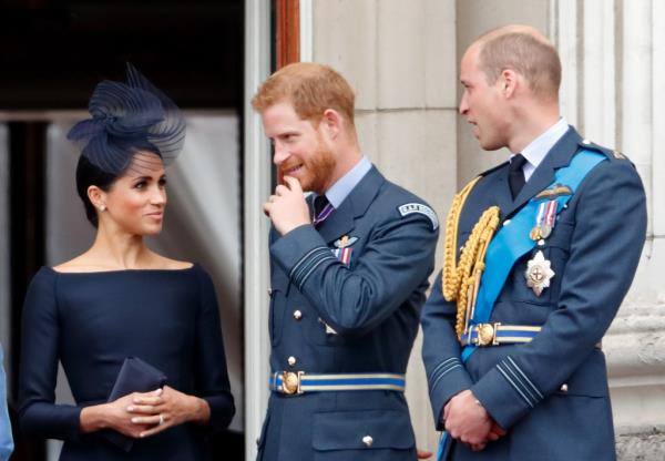 Meghan, Duchess of Sussex, Prince Harry, Duke of Sussex, and Prince William, Duke of Cambridge, watching a flypast from Buckingham Palace balcony to celebrate the centenary of the Royal Air Force