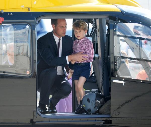 Prince William, Duke of Cambridge, holding Prince George of Cambridge in the door of a helicopter during their official visit to Germany