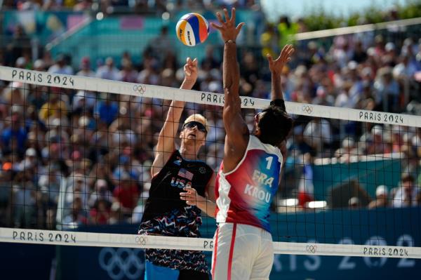 United States' Chase Budinger hits the ball by France's Youssef Krou in a beach volleyball match at the 2024 Summer Olympics, Monday, July 29, 2024, in Paris, France. 